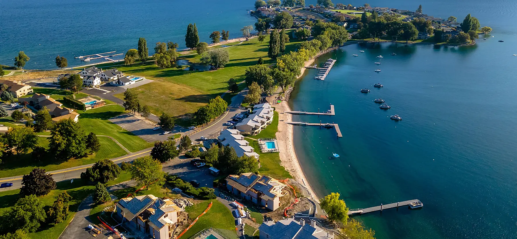 Aerial view of Wapato Point reaching into Lake Chelan, with lawns, beach and boat docks